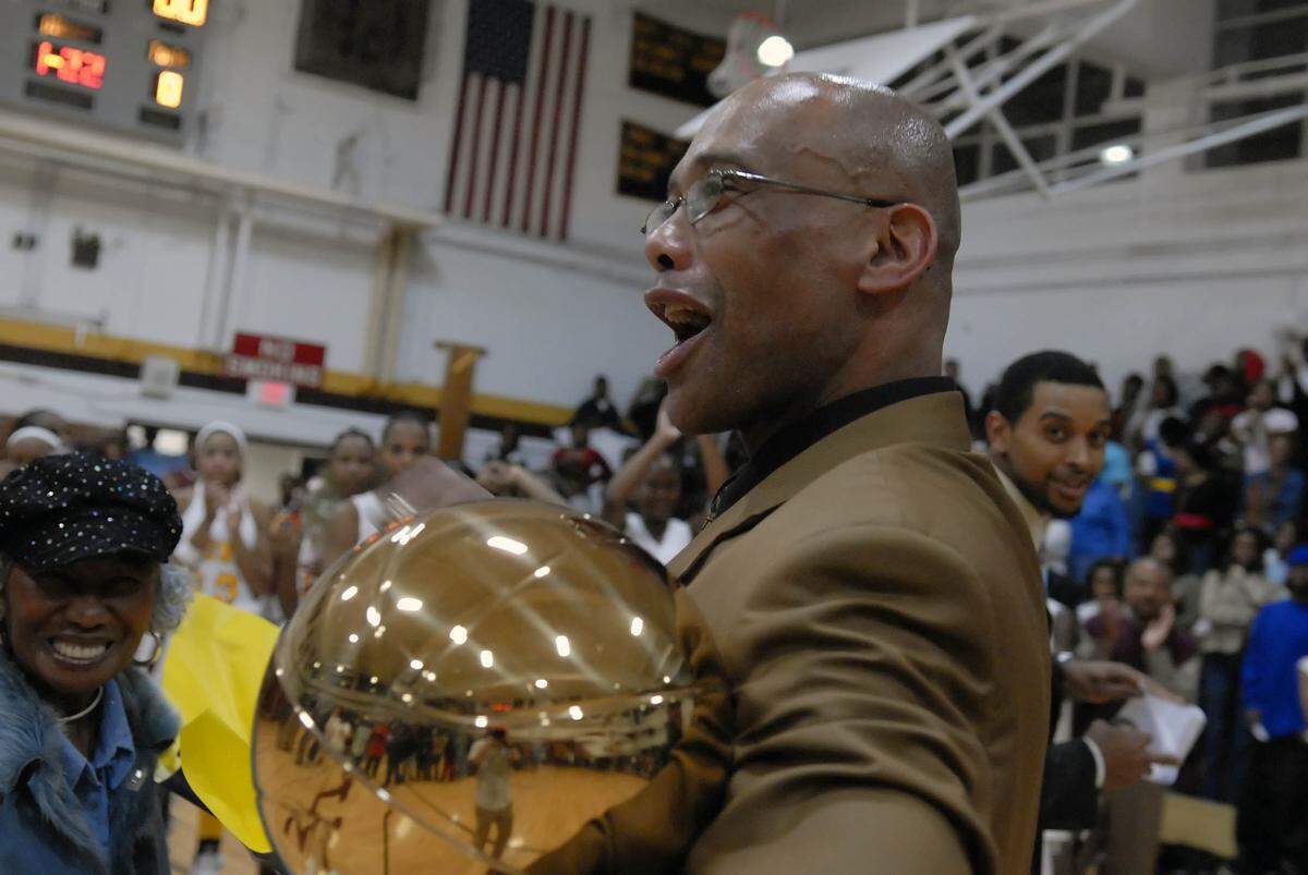 West Charlotte coach Gosnell White cheers after receiving a trophy commemorating his retirement from coaching. 