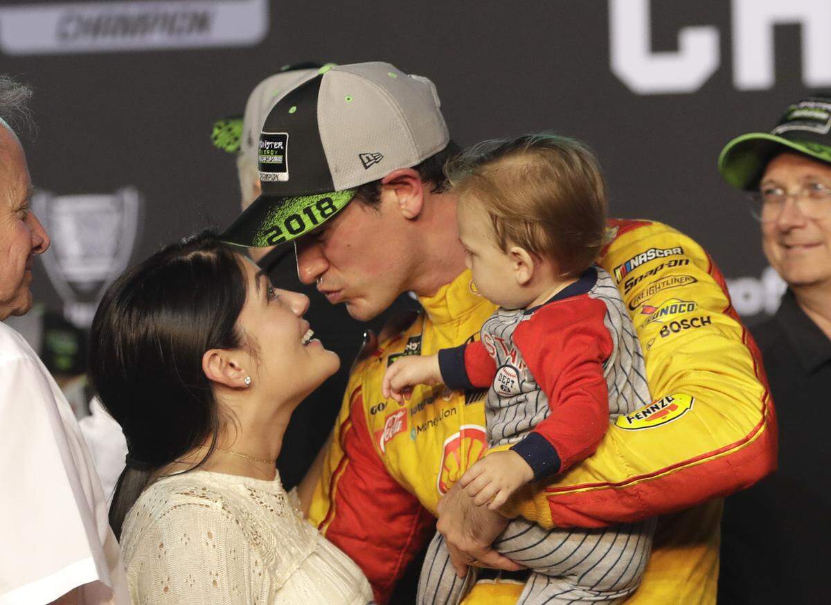 Joey Logano, his wife Brittany Baca, and their son Hudson celebrated after Logano won the NASCAR Cup Series title race at Homestead, his third win of the season.