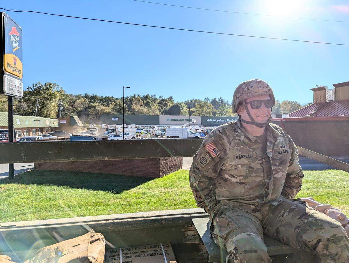 Sgt. Jared Marshall, from New Jersey and stationed in Fort Liberty in Fayetteville, talks Wednesday, Oct. 9, 2024, while riding in the back of a nLMTV. He’s headed to donation distribution centers following Hurricane Helene in Spruce Pine and Bakersville.