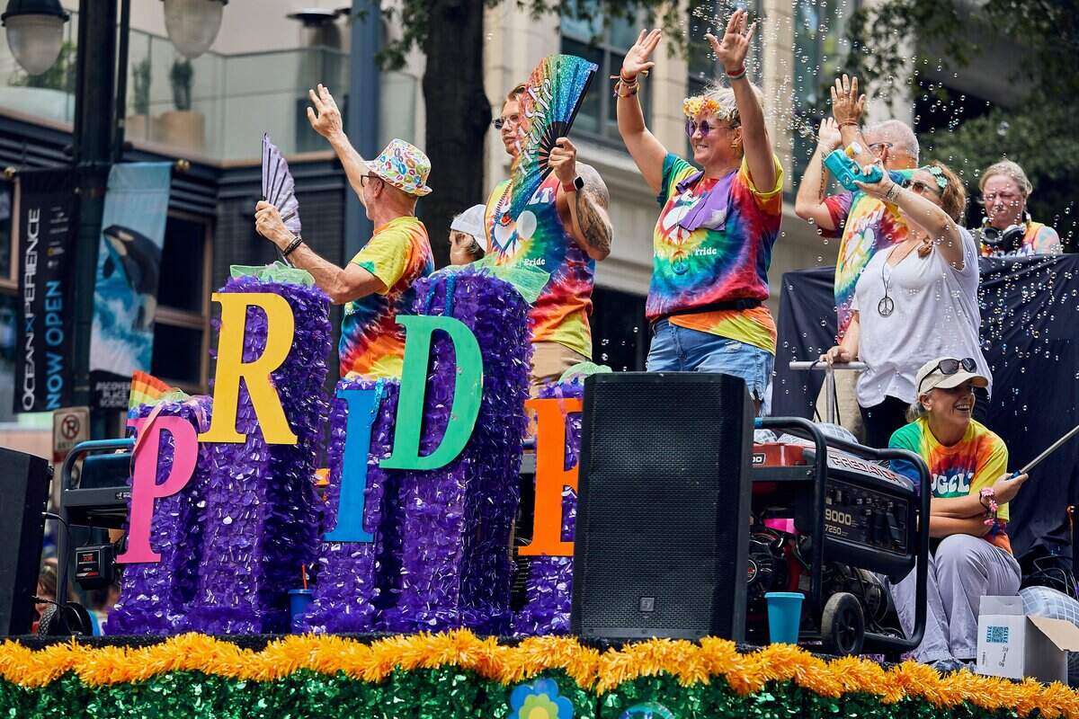 The HugCLT float travels down North Tyron Street as bubbles, fans, and music fill the parade route during the 25th Charlotte Pride Parade in uptown Charlotte on August 17, 2025.