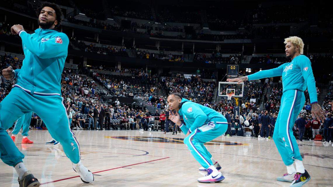 From left, Charlotte Hornets forward Miles Bridges, Charlotte Hornets forward P.J. Washington and Charlotte Hornets guard Kelly Oubre Jr. dance during warmups in the first half of an NBA basketball game Thursday, Dec. 23, 2021, in Denver. (AP Photo/David Zalubowski)