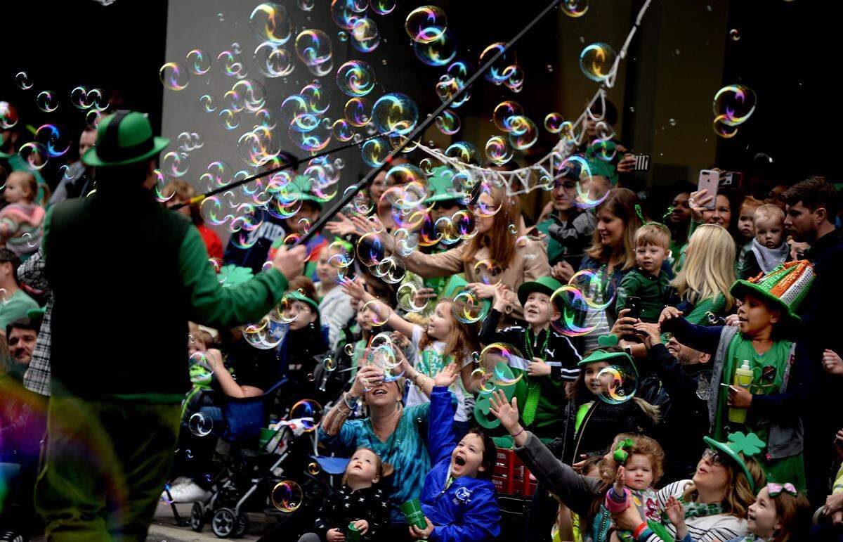 Children reach for bubbles during the 2018 St. Patrick’s Day Parade. Frank Hart, who started the parade with his wife, Linda Dyer Hart, cited his worsening Parkinson’s disease for ending the popular event. The parade would have celebrated its 25th year in March.