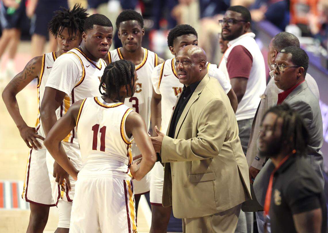West Charlotte Lions head basketball coach Jacoby Davis, center, speaks to his team during a timeout in the NCHSAA 8A state championship game at Lawrence Joel Veterans Memorial Coliseum in Winston-Salem, North Carolina, on Wednesday, March 11, 2026. West Charlotte defeated Hoggard 70-68.
