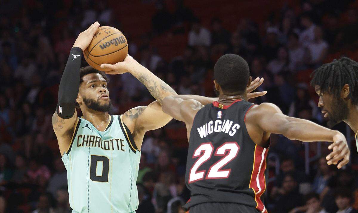 Charlotte Hornets forward Miles Bridges (0) is defended by Miami Heat forward Andrew Wiggins (22) during the first half at Kaseya Center.