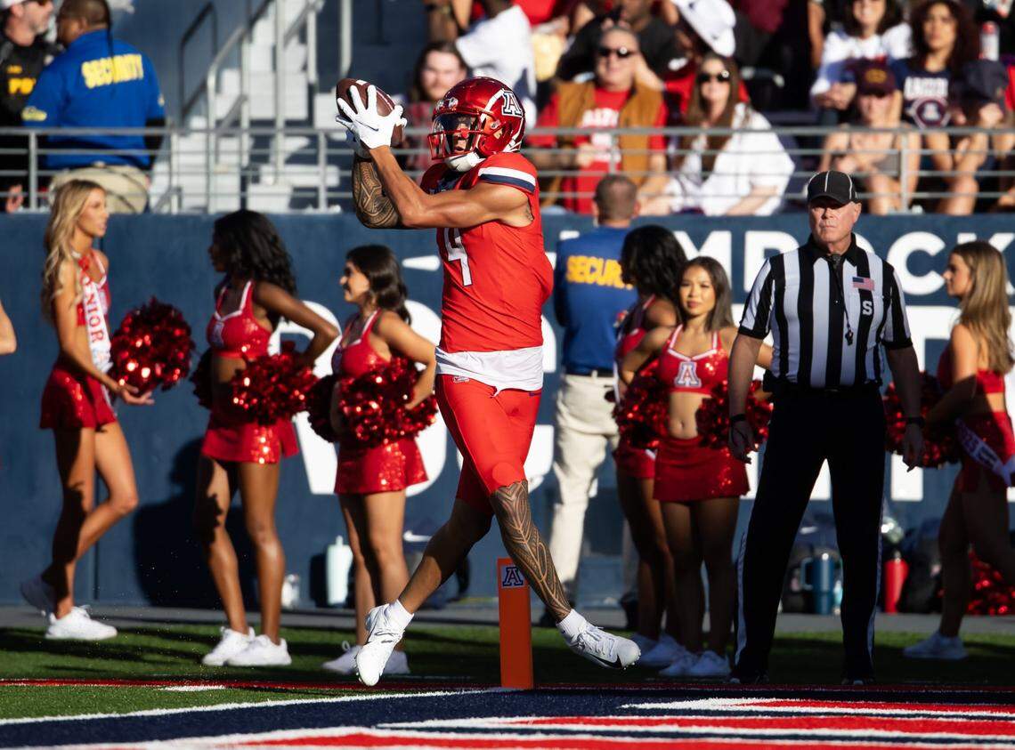 Nov 30, 2024; Tucson, Arizona, USA; Arizona Wildcats wide receiver Tetairoa McMillan (4) catches a touchdown against the Arizona State Sun Devils in the second half during the Territorial Cup at Arizona Stadium. Mandatory Credit: Mark J. Rebilas-Imagn Images