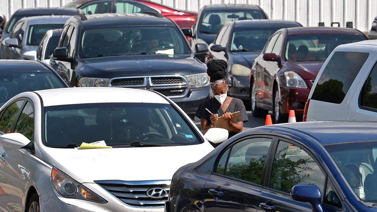Kalia Sheffield, a medical scribe with StarMed Healthcare takes notes from clients waiting to take a COVID-19 test on Wednesday, August 11, 2021 along Tuckaseegee Road in Charlotte, NC.