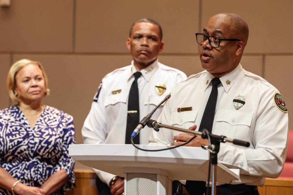 Fire Chief Reginald Johnson, far right, answers media questions following the fire department’s efforts extinguishing the five-alarm fire that tore through a construction site Thursday in South Park.