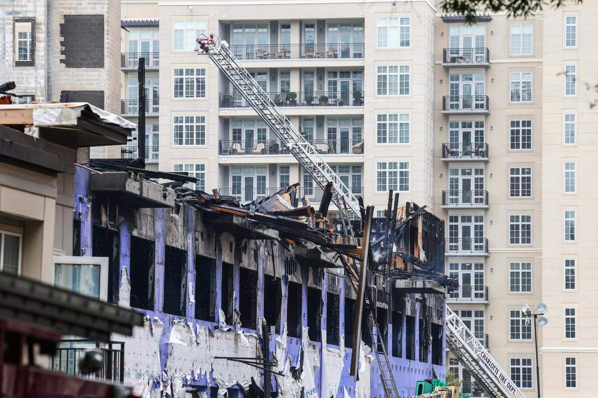 Rubble continues to smolder Friday morning after a five-alarm fire that ravaged a construction site in South Park Thursday morning. The building behind the remains is Barclay Downs at South Park, a senior living community where several residents had a direct view to the fire as it unfolded.