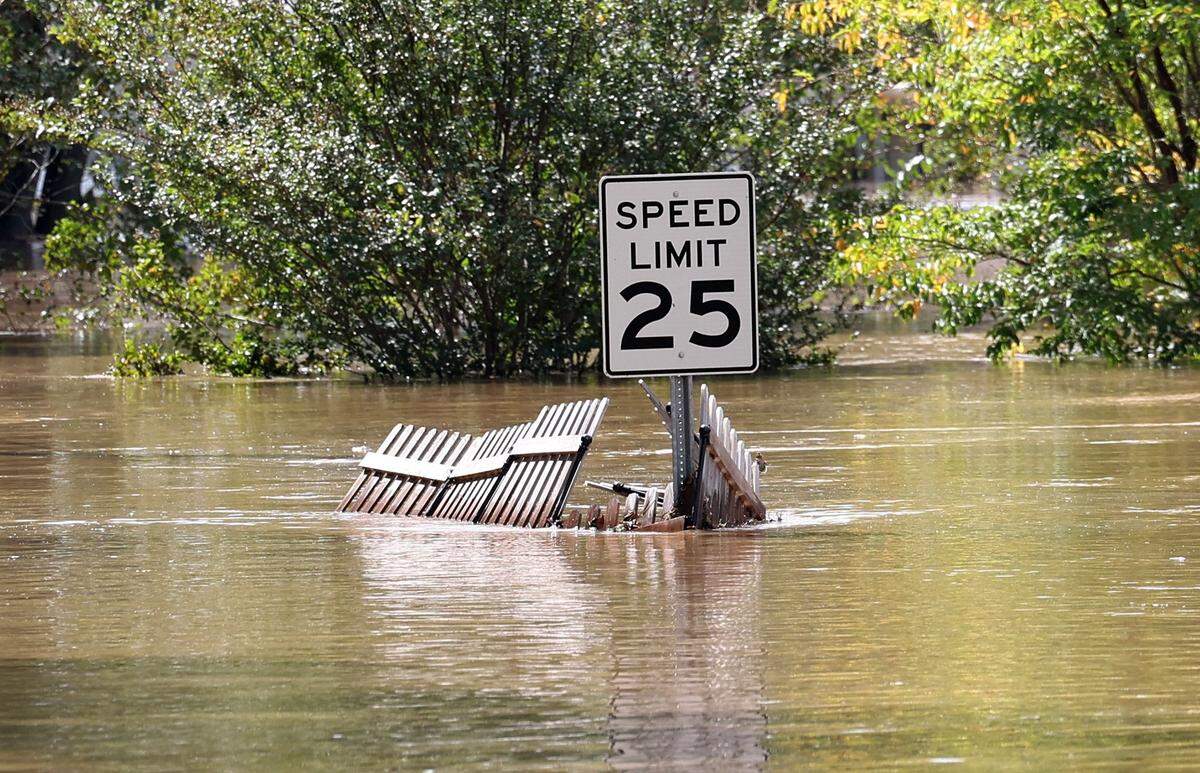 A speed limit sign is wrapped in fencing as floodwater from the Catawba River passes near the intersection of Lake Drive on Saturday, September 28, 2024.