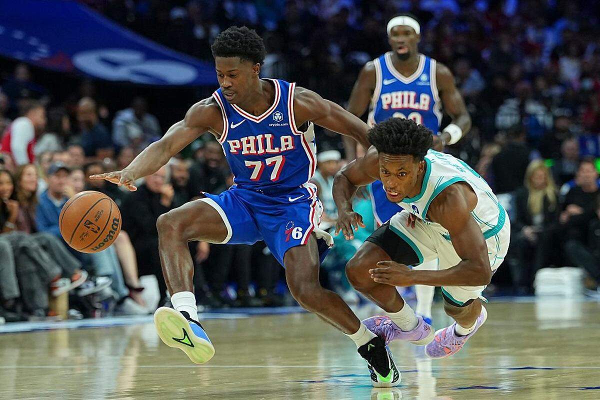 VJ Edgecombe (77) of the Philadelphia 76ers and Collin Sexton of the Charlotte Hornets battle for the ball in the first half at Xfinity Mobile Arena on October 25, 2025 in Philadelphia, Pennsylvania.