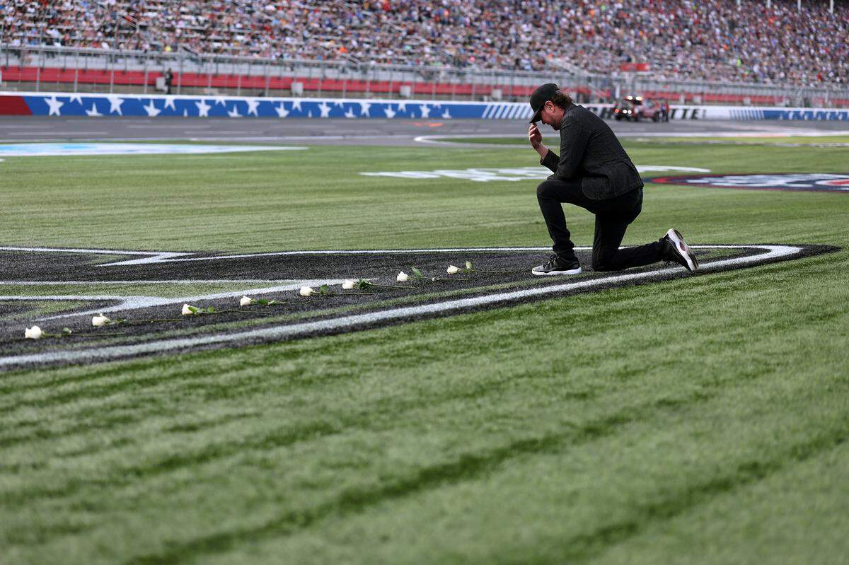 NASCAR Hall of Famer Kurt Busch lays white roses on the "8" stenciled of the infield grass during the remembrance ceremony for his brother, Kyle Busch, who passed away suddenly at the age of 41, prior to the NASCAR Cup Series Coca-Cola 600 at Charlotte Motor Speedway on May 24, 2026 in Concord, North Carolina.