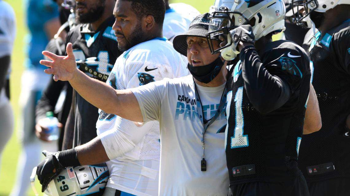 Carolina Panthers defensive coordinator Phil Snow talks with safety Juston Burris (31) in 2020.