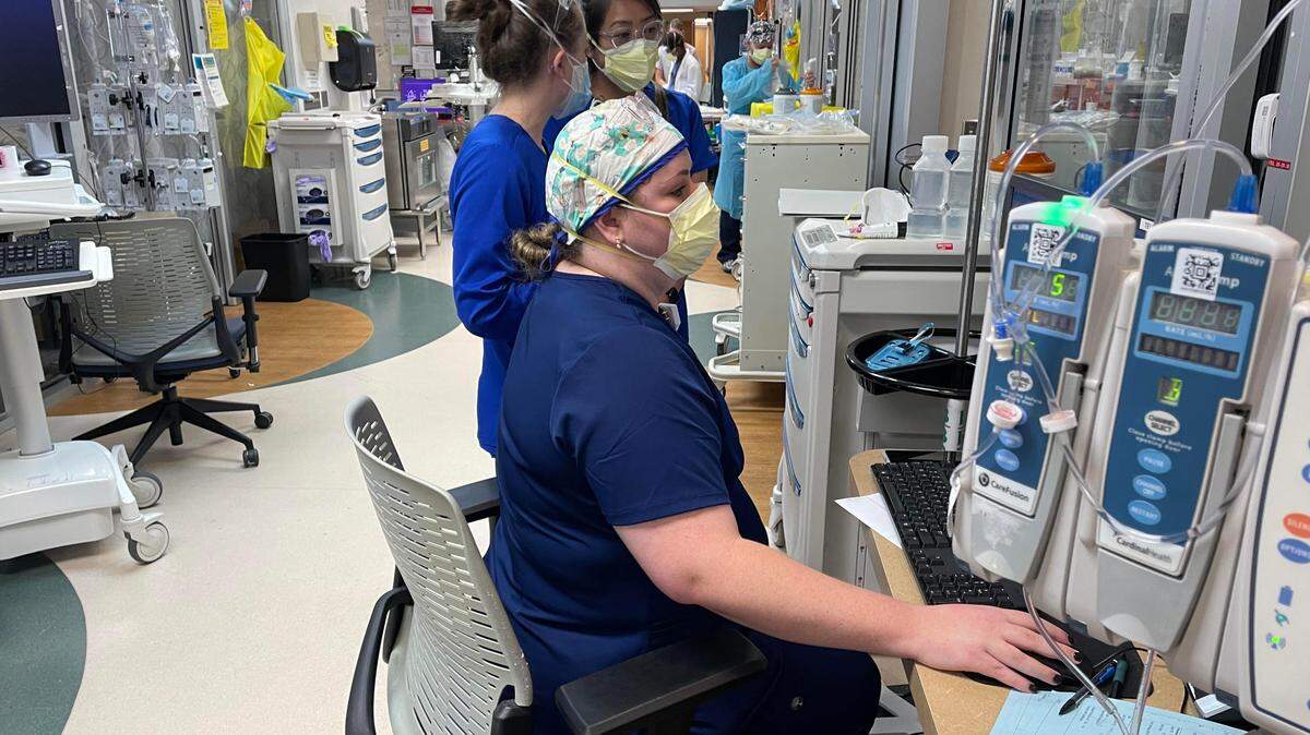 Novant Health ICU team members gather outside a patient’s room to discuss the patient’s progress and treatment options. ICU and other COVID-19 units across North Carolina have been swamped with unvaccinated patients in recent weeks.