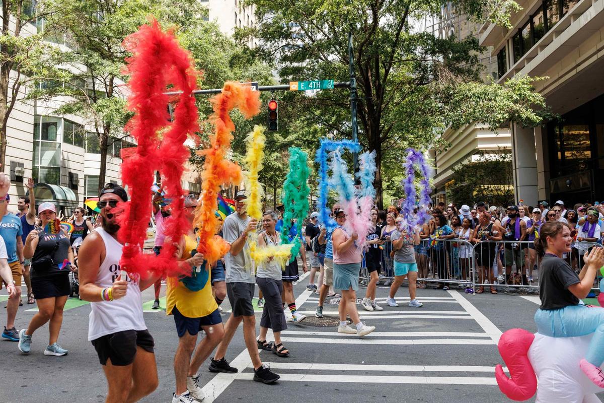 Participants representing Watershed, a non-denominational church in Charlotte, hold up letters that spell “Be Loved”during the Charlotte Pride Festival & Parade on Sunday, Aug. 18, 2024