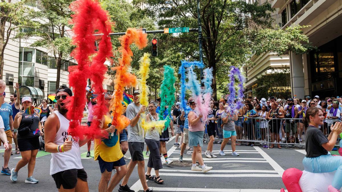 Participants representing Watershed, a non-denominational church in Charlotte, hold up letters that spell “Be Loved” at the 2024 Charlotte Pride Festival & Parade.