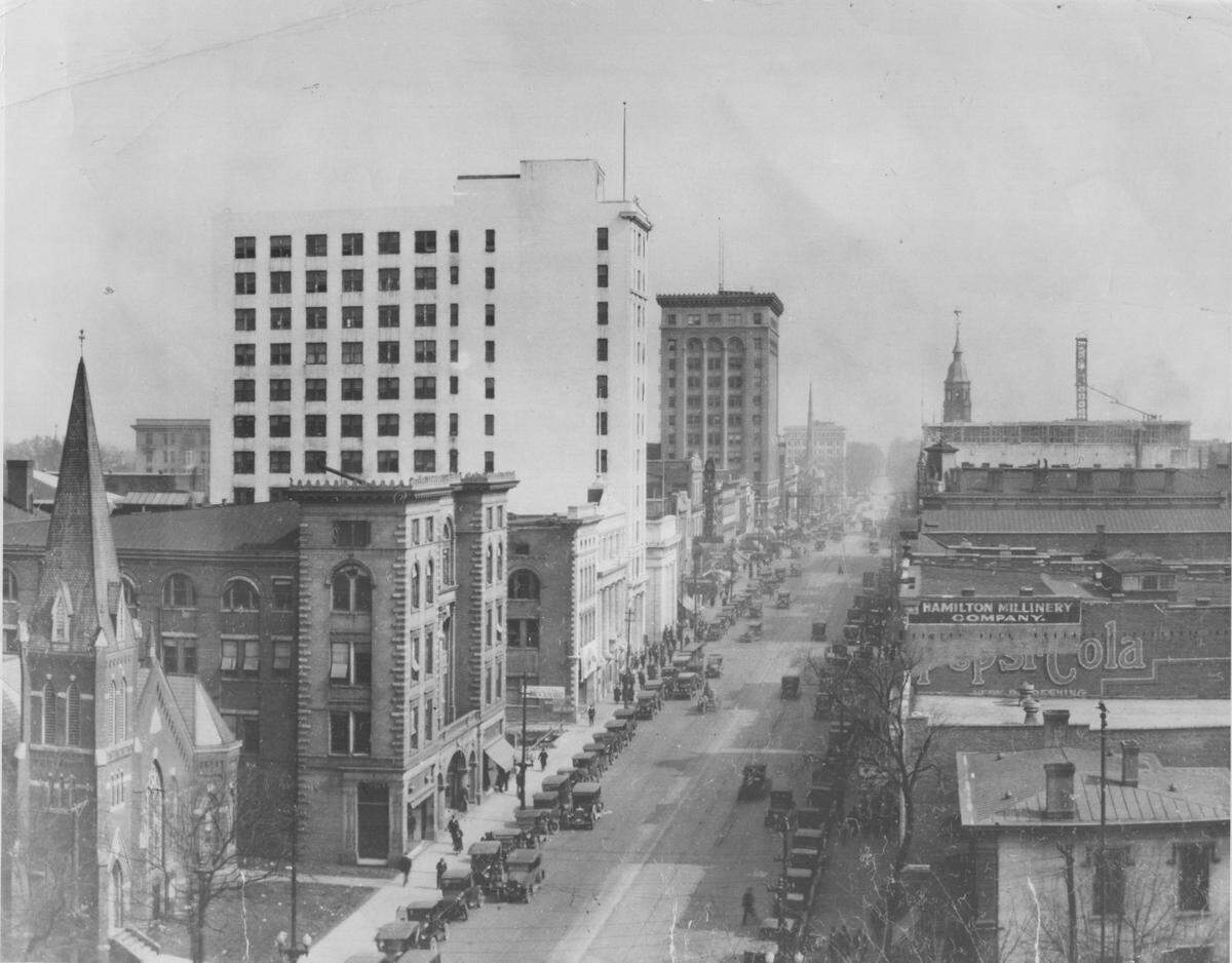 Looking north on Tryon St. from County Courthouse in mid-1920’s. The Independence building (center) was built in 1908. The 12-story building was noted in newspaper articles as the first steel frame tower built in North Carolina. In September 1981, the building was imploded after it was sold to developer Henry Faison, according to the Historic Landmarks Commission.