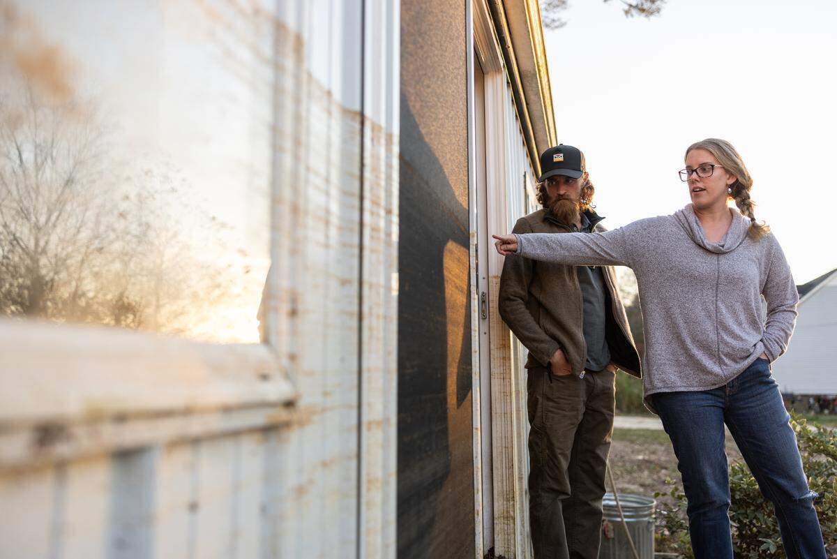 Mitchell Peterson, left, and his fiancee Jennifer Kleine-Jaeger, photographed pointing out how high the water got on the Lake Drive home they plan to give up.