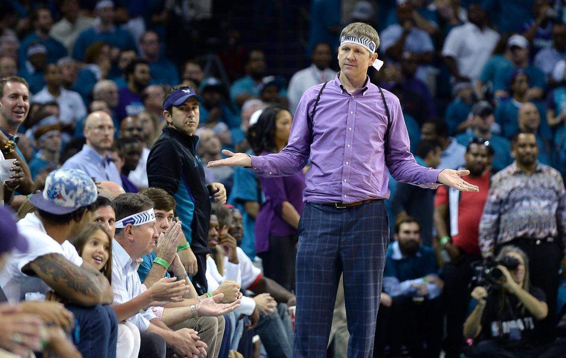 Charlotte Hornets fan Michael Deason looks toward NFL star Julius Peppers, left with white t-shirt and Hornets cap, after Peppers slapped hands with Miami Heat guard Dwyane Wade following a basket during second half action of Game 6 of the First Round of the NBA Playoffs. The Hornets lost to the Heat 97-90 at Time Warner Cable Arena in Charlotte, NC on Friday, April 29, 2016.