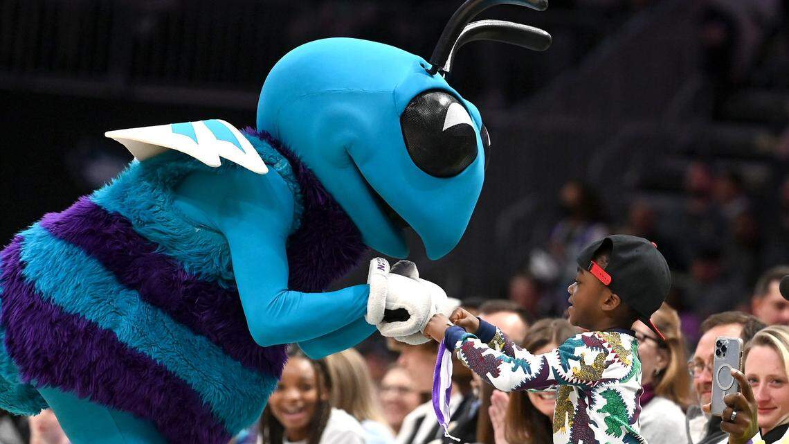 Charlotte Hornets mascot Hugo the Hornet fist bumps a young fan along the court during the teamÕs game against the Washington Wizards at Spectrum Center in Charlotte, NC on Sunday, April 10, 2022. The Hornets defeated the Wizards 124-108.