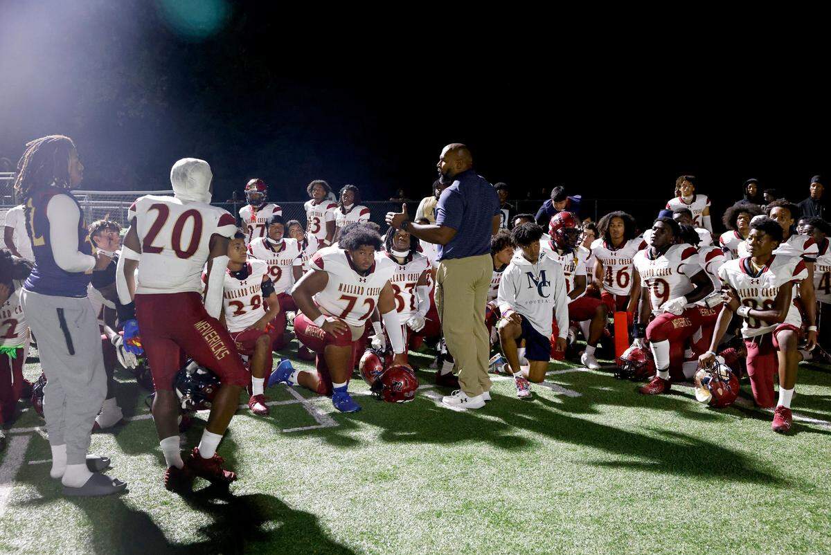 Mallard Creek Mavericks head football coach Kennedy Tinsley, center, speaks to his team following the chaotic scene of players and fans scrambling for safety during a disturbance at the team’s game with West Charlotte on Friday, September 20, 2024.
