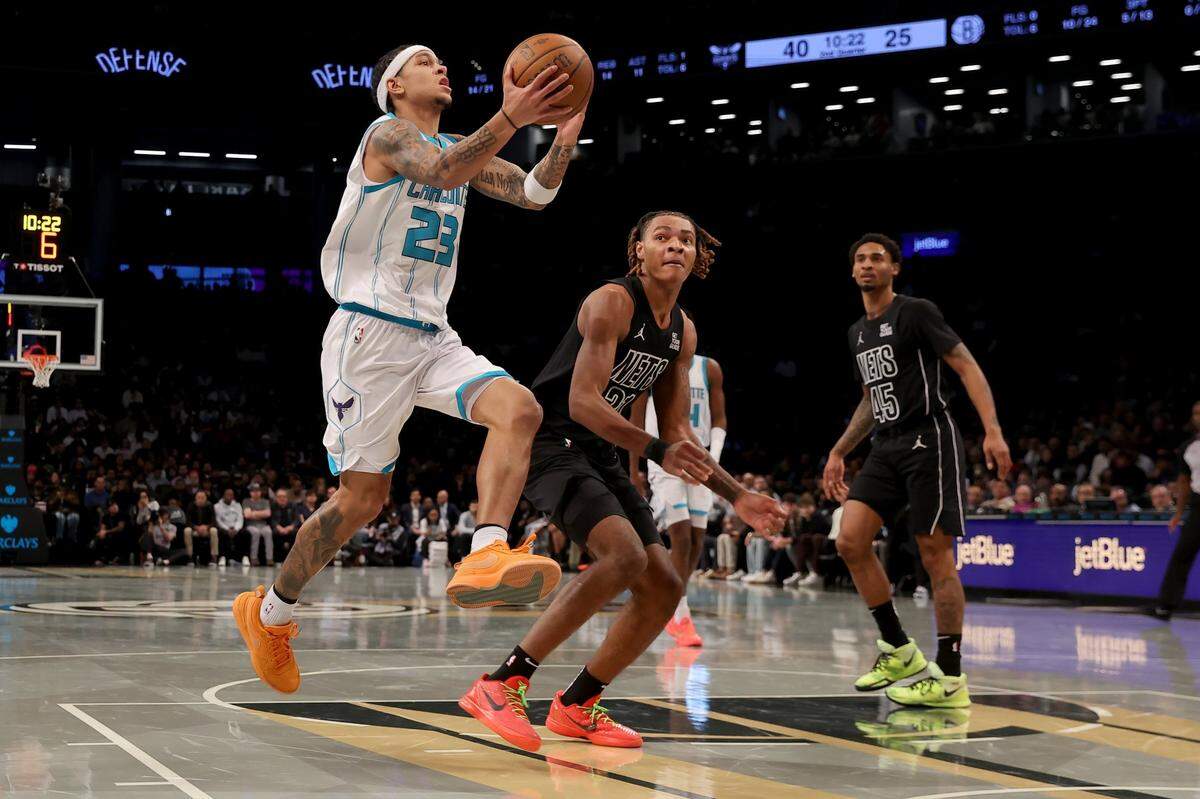 Charlotte Hornets guard Tre Mann (23) drives to the basket against Brooklyn Nets forward Noah Clowney (21) and guard Keon Johnson (45) during the second quarter at Barclays Center.