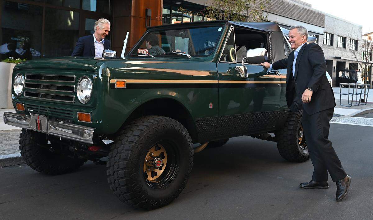 North Carolina Gov. Josh Stein, right, closes the door on a Scout Motors vehicle after driving up to a press conference where it was announced that the company is making Charlotte its new corporate headquarters on Tuesday. Scout Motors President Scott Keogh, left, exits the passenger side of the vehicle.