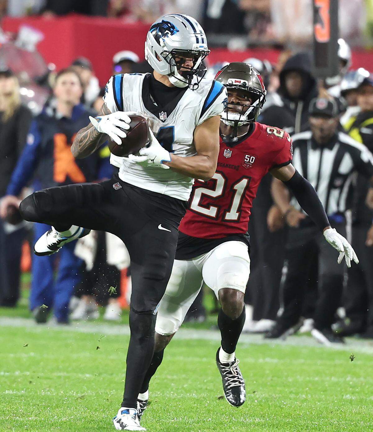 Carolina Panthers wide receiver Tetairoa McMillan, left, catches a deep pass from quarterback Bryce Young as Tampa Bay Buccaneers cornerback Benjamin Morrison, right, looks on during action at Raymond James Stadium in Tampa, FL.on Saturday, January 3, 2026. McMillan was called for offensive pass interference on the play. The Buccaneers defeated the Panthers 16-14.