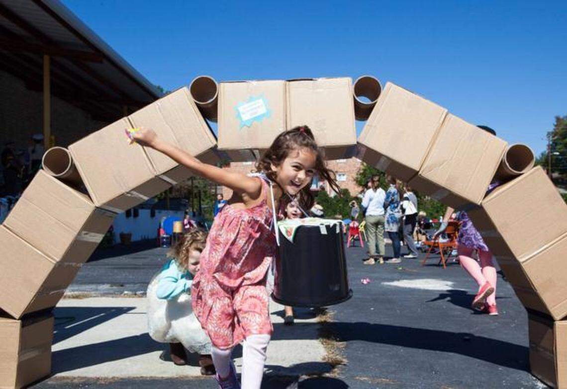 Ruby Monje Silva, 5, runs out from under a cardboard bridge during the grand opening celebration of The Scrap Exchange in Durham on Sunday Oct. 5, 2014. The Scrap Exchange is a nonprofit that collects unwanted materials from the community to redistribute for creative reuse in their new 1,200 square foot facility on Chapel Hill Road.