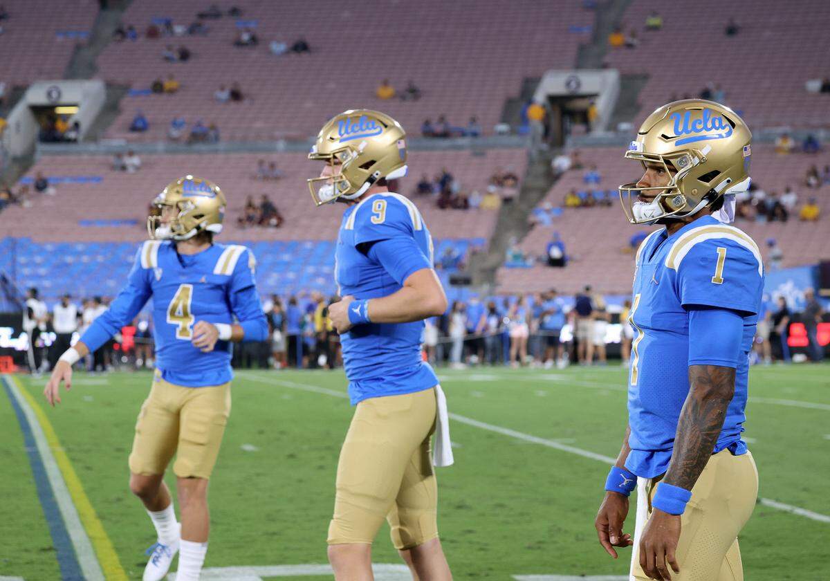 UCLA Bruins quarterbacks Parker McQuarrie, center, Dorian Thompson-Robinson, left, and Ethan Garbers warm up before their game against Arizona State at the Rose Bowl on October 2, 2021, in Pasadena, California.