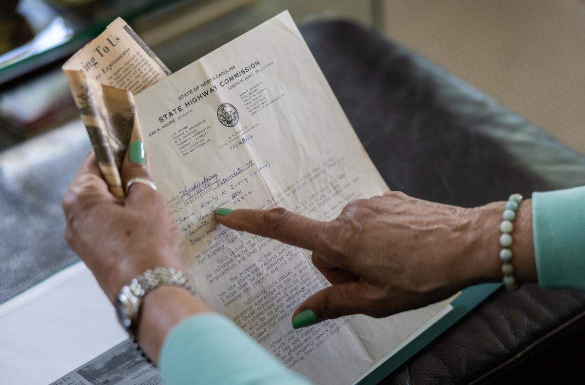 Darnell Ivory looks through documents and newspaper clippings from when her and her family were displaced by I-77 back in 1966 in Charlotte, N.C., on Friday, April 10, 2026. 