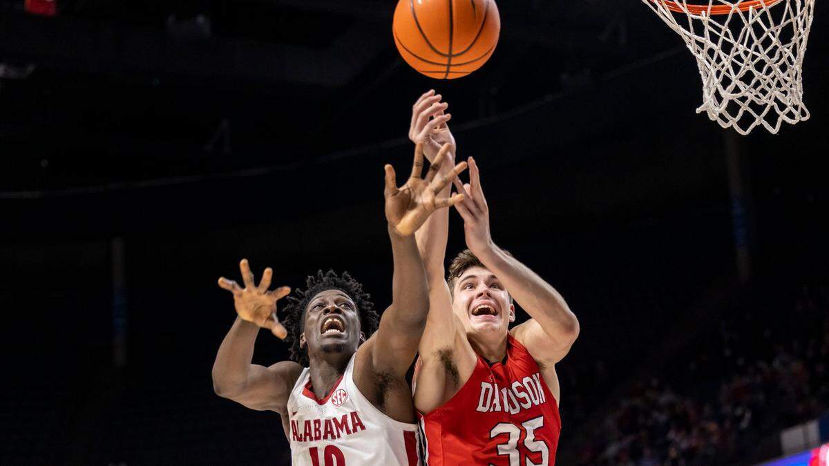 Alabama center Charles Bediako (10) and Davidson forward Luka Brajkovic (35) chase a loose ball during their game in Birmingham, Ala., on Tuesday. Davidson won, 79-78, the Wildcats’ first victory over a top 10 team since 2008. (AP Photo/Vasha Hunt)