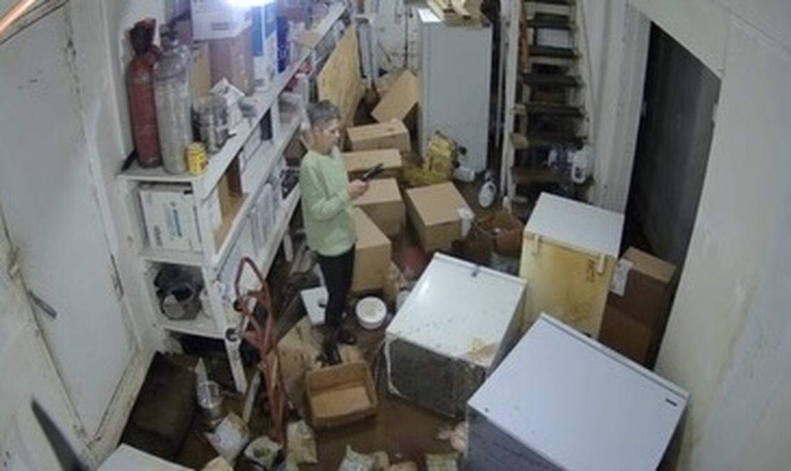 The security camera at Helen’s Restaurant shows owner Donna Stafford looking at the damage of her flooded basement at 6:50 a.m. on Thursday, Sept. 26. A powerful storm in Bakersville, NC, caused the basement to flood two days before Hurricane Helene arrived.