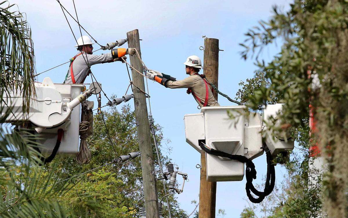 Duke Energy linemen work to replace a utility pole in Maitland, Fla., in September 2017 after Hurricane Irma damaged the area.