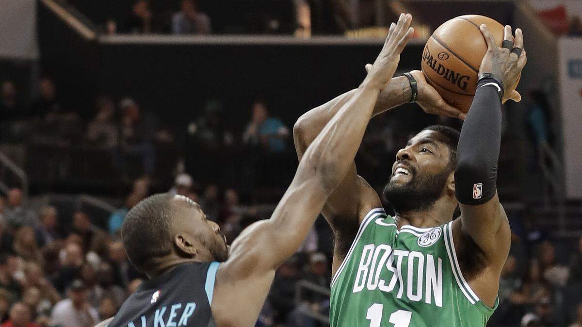 Boston Celtics guard Kyrie Irving (11) shoots over Charlotte’s Kemba Walker (15) in the first half of Monday’s game in Charlotte. The Hornets beat the Celtics 117-112, and Walker finished with 43 points.