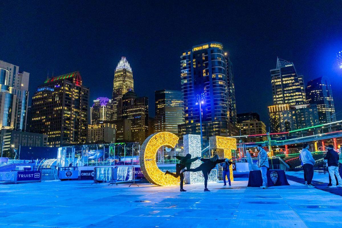 People gather at the CLT letters at the Light the Knights Festival at Truist Field in Uptown, Charlotte.