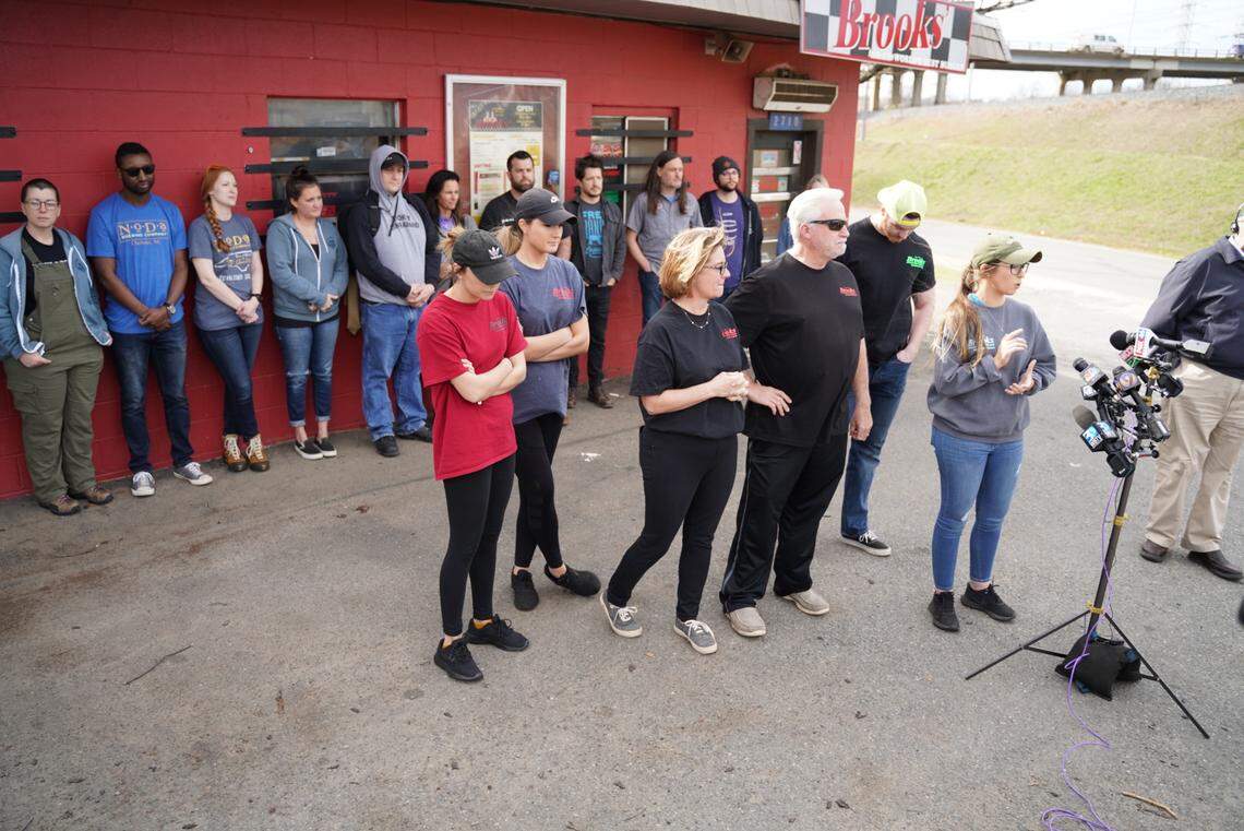 Lauren Brooks talks to the media about the new safety measures for the employees of Brooks’ Sandwich House. The restaurant will open later so employees don’t have to arrive in the dark. Breakfast will no longer be served. Standing behind her are representatives from several local breweries who are brewing a beer in memory of Scott Brooks. Proceeds will benefit Habitat for Humanity.