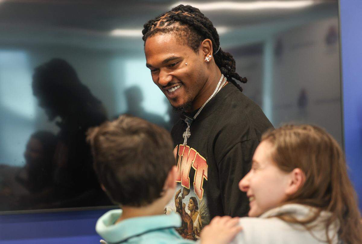 Panthers running back Rico Dowdle smiles at a young fan at Children's Home Society of North Carolina (CHS) in Charlotte, NC on Friday, November 14, 2025. Dowdle presented CHS with a check for $45,000 as a he turned a penalty into purpose, transforming a fine for his touchdown celebration into a charitable cause.