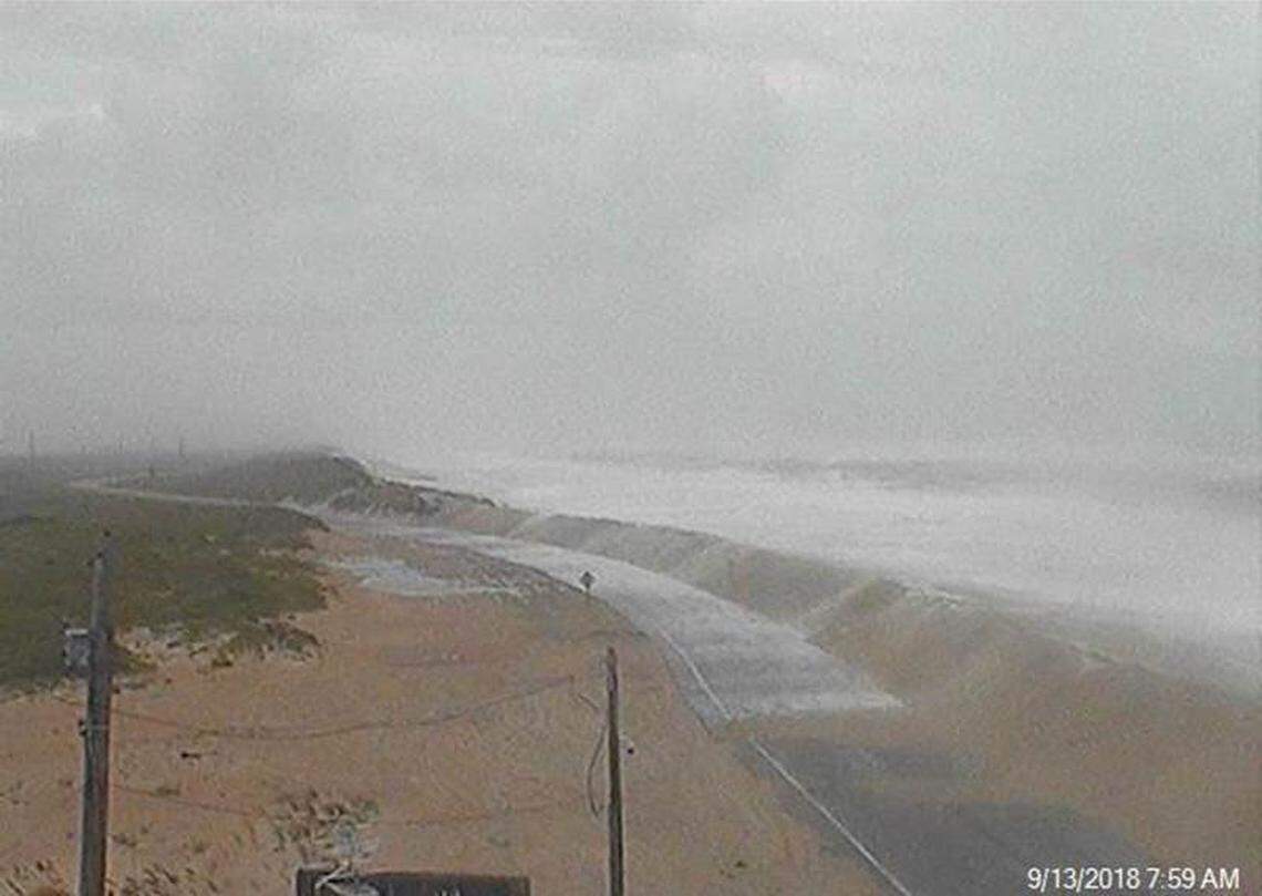 NC 12 early Thursday, as waves generated by Hurricane Florence covered the highway with sand and surf.