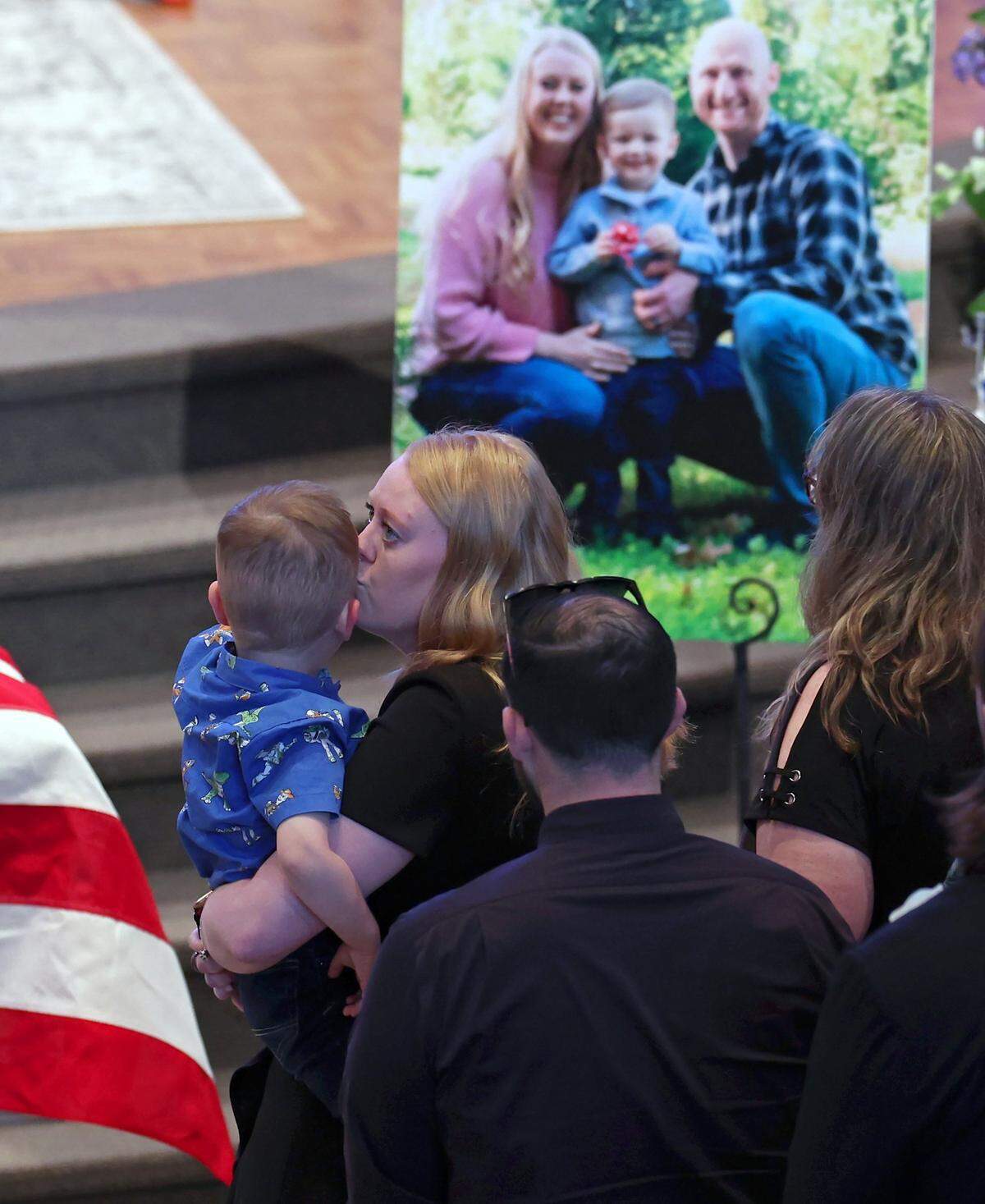 Andrew Eyer, 2 yrs., is kissed by his mother, Ashley Eyer during the funeral for his father Joshua Eyer at First Baptist Church in Charlotte, NC on Friday, May 3, 2024. Mourners gathered at First Baptist Church to honor slain Charlotte-Mecklenburg Police Officer Joshua Eyer who died from wounds sustained during a standoff with a gunman on Monday, April 29th.