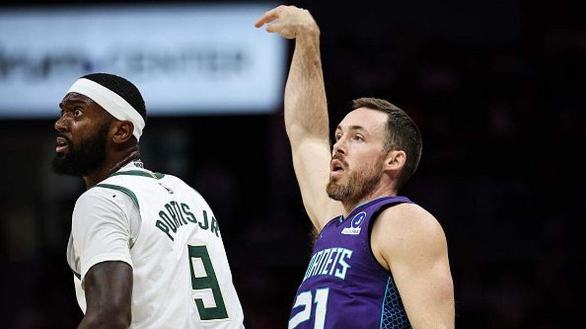 Pat Connaughton #21 of the Charlotte Hornets shoots the ball over Bobby Portis #9 of the Milwaukee Bucks during the first half of a basketball game at Spectrum Center on November 12, 2025 in Charlotte, North Carolina.