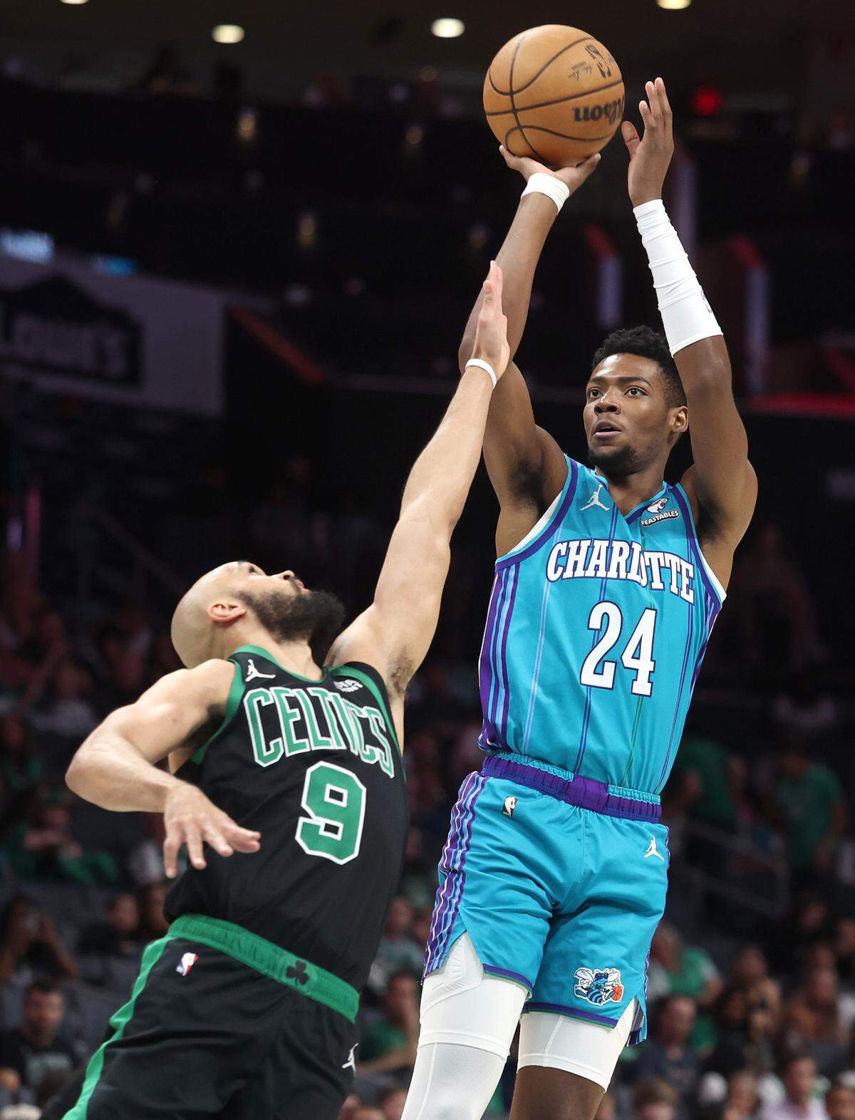 Charlotte Hornets forward/guard Brandon Miller, right, releases a jump shot over Boston Celtics guard Derrick White, left, during first quarter action at Spectrum Center in Charlotte, NC on Monday, April 1, 2024.