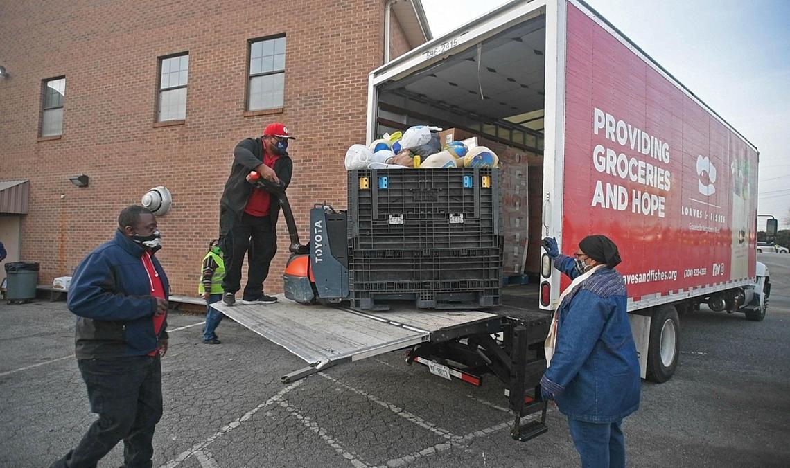 Volunteers from Greater Salem Church help unload a truck from Loaves & Fishes for a mobile food pantry distribution site on Tuesday, November 24, 2020.