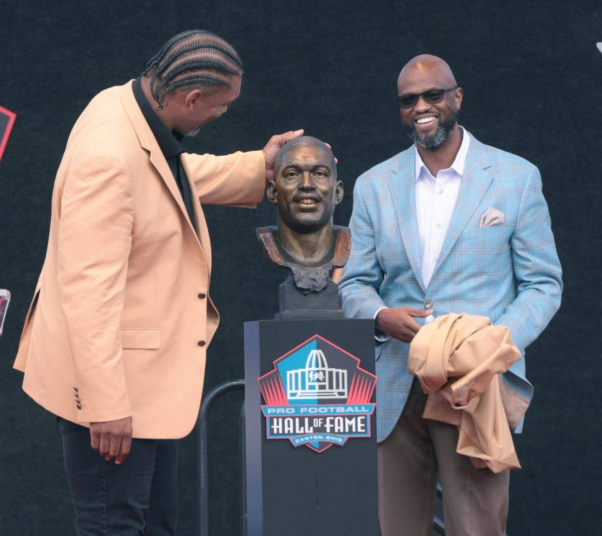 The Carolina Panthers Julius Peppers admires his bust along with his presenter longtime friend Carl Carey at the 2024 Pro Football Hall of Fame Enshrinement at Tom Benson Hall of Fame Stadium Saturday, Aug. 3, 2024.
