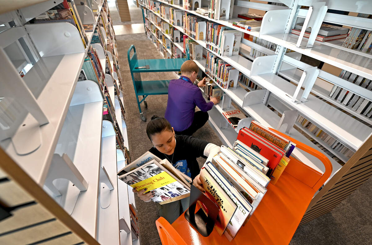 University City Regional Library assistants Jennifer Hernandez, left and John Peitzman, right, empty and organize book shelves in the adult non-fiction section on Thursday, January 30, 2025. The new library facility will be opening less than a mile from the current building in February 2025.
