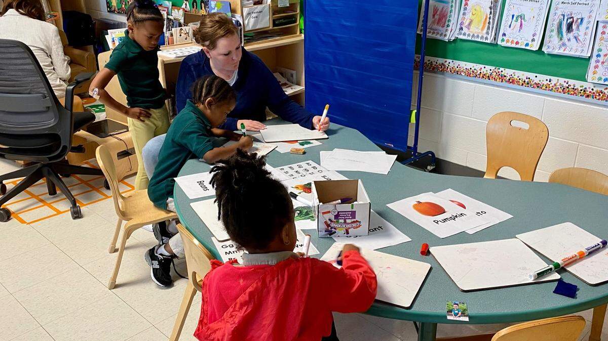 A teacher works with pre-K students at Charles Drew Charter Academy.