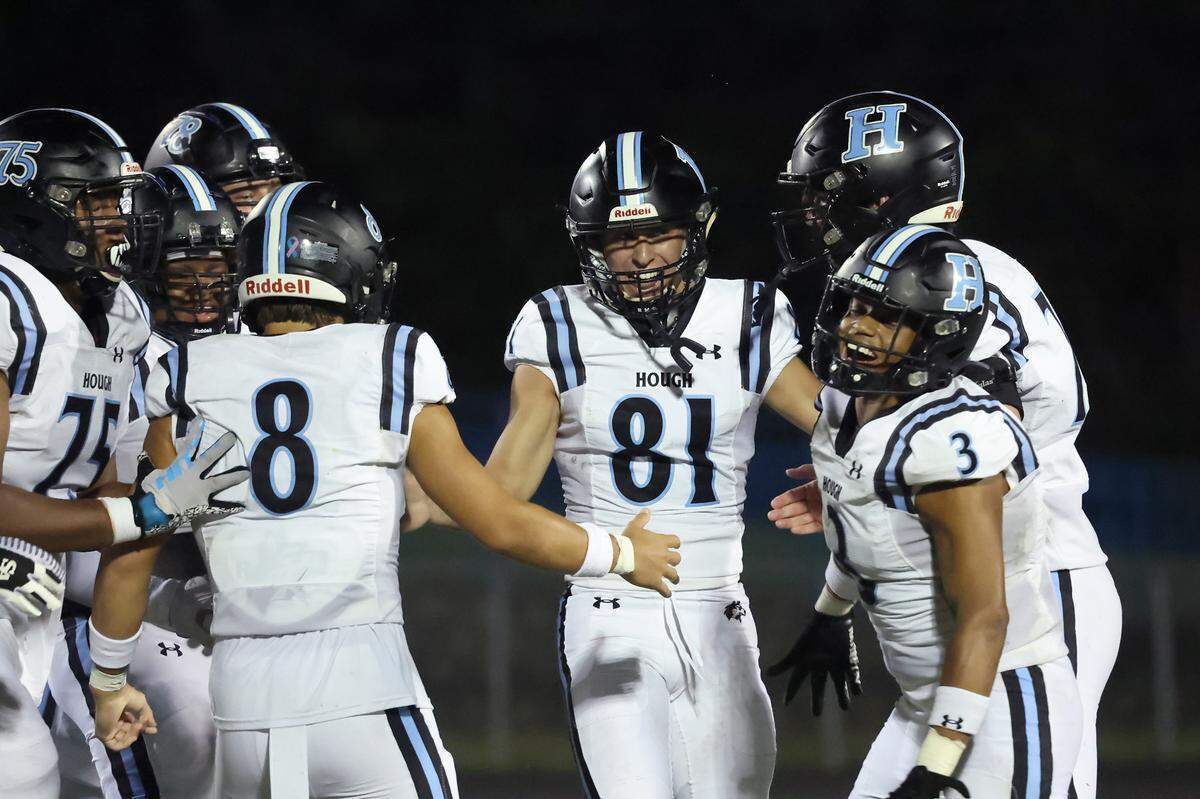 Hough Huskies kicker Nolan Hauser, center, is mobbed by his teammates following his national record breaking kick during third quarter action against the North Meck Vikings on Thursday, September 14, 2023 at North Meck High School. Hauser kicked his 57th career field goal.