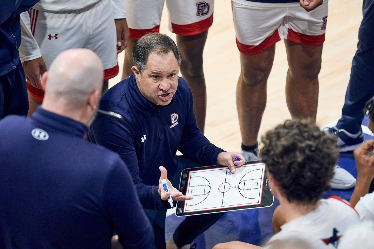 The Providence Day School Chargers head coach Jonathan McIntyre talks to his team in the huddle in their 80-75 win over Carmel Christian in the NCISAA state semifinals on February 24, 2026.