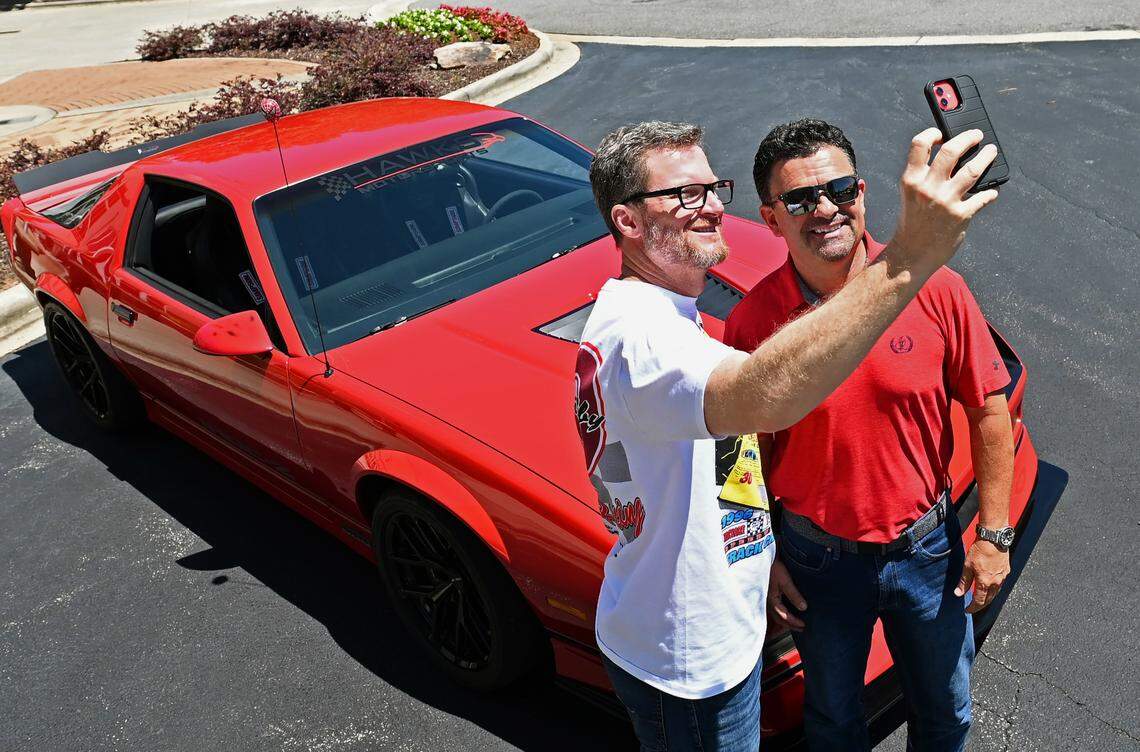 NASCAR driver and hall of fame member Dale Earnhardt Jr., left, takes a photo with a fan and his lROC Camaro at JR Motorsports in Mooresville, NC. Fans often show up unannounced at the shop, hoping to catch a glimpse of Earnhardt.