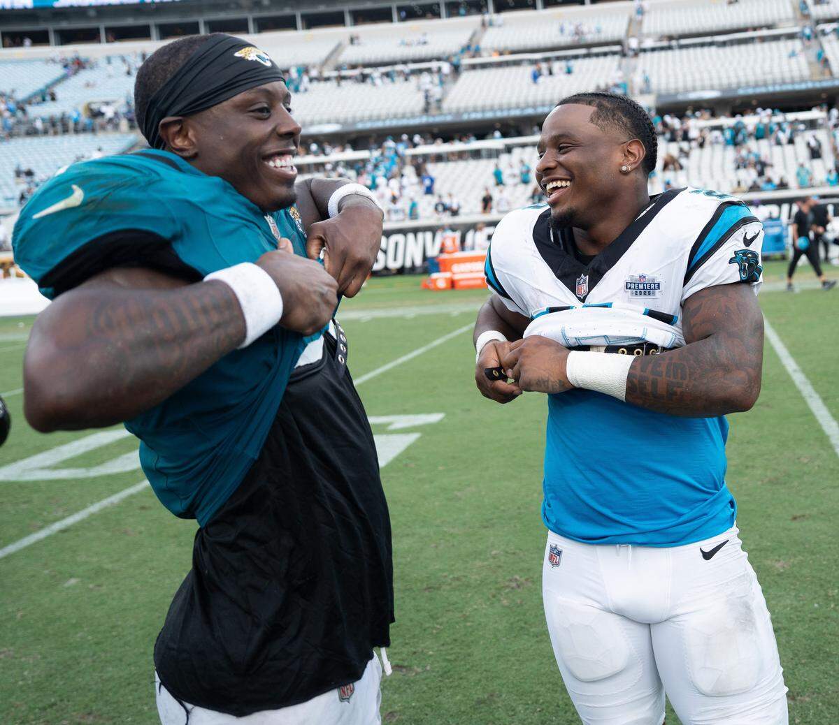 Jacksonville Jaguars running back Travis Etienne Jr. (1) and his brother Carolina Panthers running back Trevor Etienne (23) exchange jerseys after the game between the Carolina Panthers at Jacksonville Jaguars at EverBank Stadium Sunday September 7, 2025. Jaguars defeated the Panthers 26-10. [Doug Engle/Florida Times-Union]