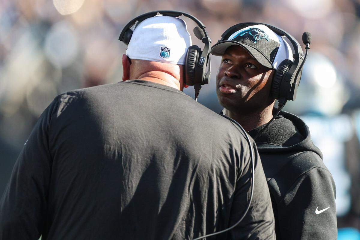 Panthers Defensive Coordinator Ejiro Evero talks with another coach on the sideline during the game against the Cowboys at Bank of America Stadium on Sunday, November 19, 2023 in Charlote, NC.